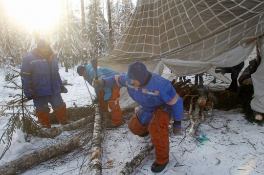 Astronauts and cosmonauts chopping wood for a fire.