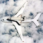 The Buran space shuttle mounted on a transport plane in flight.